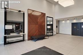 Oakville (Go Glenorchy) condo for rent - A modern living room with a large mirror, a wooden door, and a black bench.