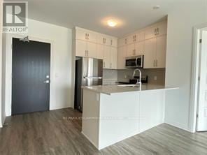 Oakville (Go Glenorchy) condo for rent - A kitchen with white cabinets and a black door.