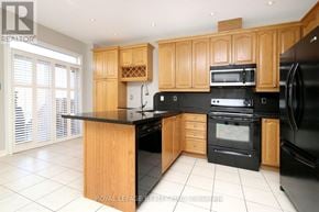 Mississauga (Applewood) apartment for rent - A kitchen with wooden cabinets and black appliances.