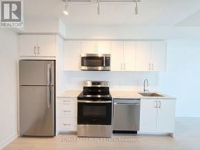 Toronto (Humber Heights) condo for rent - A kitchen with white cabinets and stainless steel appliances.