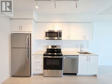 Toronto (Humber Heights) condo for rent - A kitchen with white cabinets and stainless steel appliances.