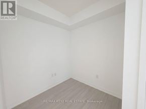 Toronto (Humber Heights) condo for rent - A white room with a wooden floor and a brokerage sign.