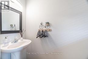 London North (North A) townhouse for rent - A white bathroom with a sink, mirror, and wall decor.