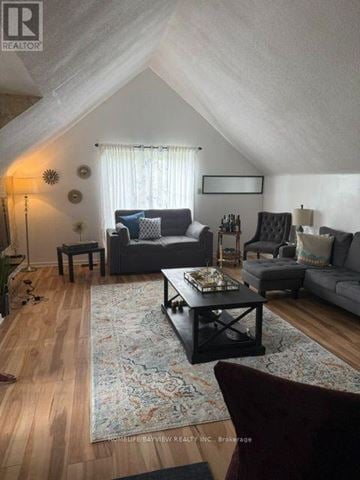 Richmond Hill (Mill Pond) apartment for rent - A living room with a grey couch, a black coffee table, and a rug with a floral pattern.