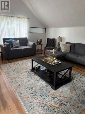 Richmond Hill (Mill Pond) apartment for rent - A living room with a grey couch, a black chair, and a coffee table with a tray on it.