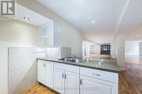 Milton (Be Beaty) apartment for rent - A kitchen with white cabinets and a marble countertop.