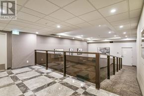 Hamilton (Durand) condo for rent - A room with grey flooring and two windows overlooking a street.