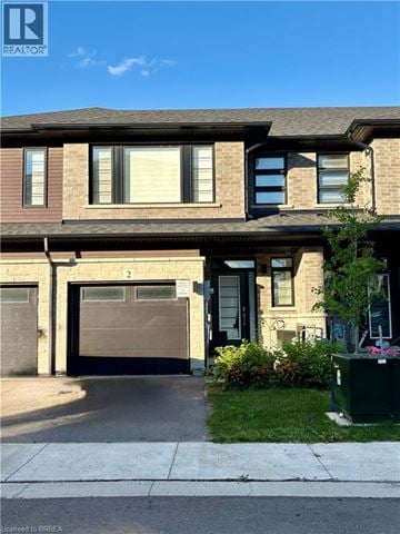 Brantford townhouse for rent - A house with a brown garage door is for sale.