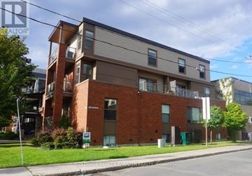Ottawa apartment for rent - A multi-story apartment building with a brick facade and a sign that reads "Cobblestone Bank".
