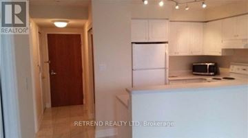 Toronto (Willowdale West) condo for rent - A kitchen with white cabinets and a refrigerator.