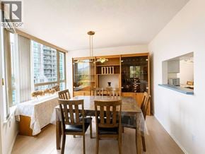 Coquitlam apartment for rent - A dining room with a table set for two and a kitchen area in the background.