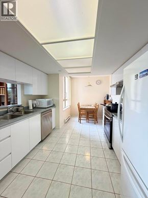 Coquitlam apartment for rent - A kitchen with white appliances and a dining table.