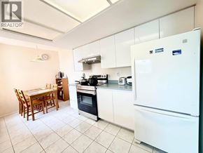 Coquitlam apartment for rent - A kitchen with white appliances and a table set for two.