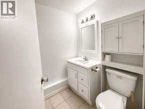 Richmond apartment for rent - A white bathroom with a toilet, sink, and medicine cabinet.
