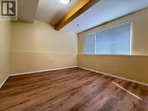 Vancouver apartment for rent - A room with wooden flooring and a window with blinds.