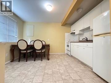 Vancouver apartment for rent - A kitchen with white cabinets and a dining table with chairs.