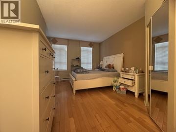 Vancouver townhouse for rent - A bedroom with a bed, dresser, and mirror.