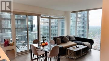 Toronto (Mount Pleasant West) condo for rent - A living room with a view of the cityscape outside the large windows.