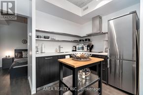 Toronto (Waterfront Communities) condo for rent - A modern kitchen with a wooden table and stainless steel appliances.