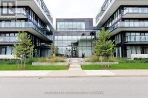 Burlington (Lasalle) condo for rent - A modern building with glass windows and balconies is surrounded by greenery.