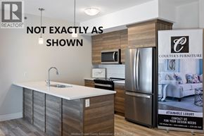 Lasalle condo for rent - A kitchen with a sink and a refrigerator with a sign that says Coulter's Furniture.