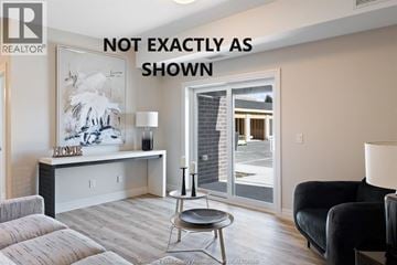 Lasalle condo for rent - A living room with a couch, a chair, and a table with a lamp on it.