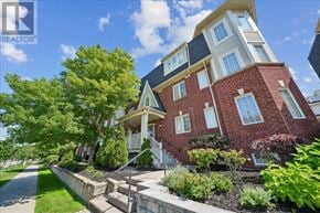Mississauga (Cooksville) townhouse for rent - A red brick house with a white trim and a green lawn in front.