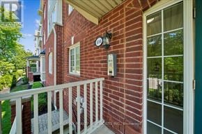 Mississauga (Cooksville) townhouse for rent - A red brick house with a white railing and a glass door.