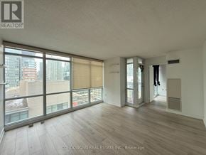 Toronto (Waterfront Communities) condo for rent - A spacious room with a view of the cityscape outside the large windows.