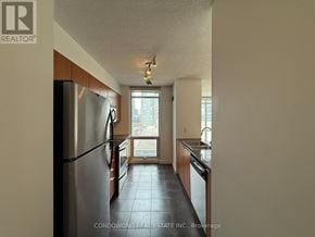 Toronto (Waterfront Communities) condo for rent - A kitchen with a refrigerator, sink, and a window.