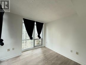 Toronto (Waterfront Communities) condo for rent - A room with a sliding glass door and wooden flooring.