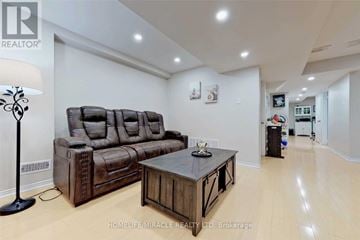 Mississauga (Churchill Meadows) apartment for rent - A living room with a brown leather sofa and a wooden coffee table.