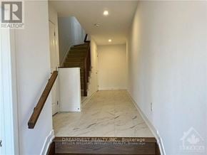 Ottawa townhouse for rent - A hallway with a staircase and a white wall.