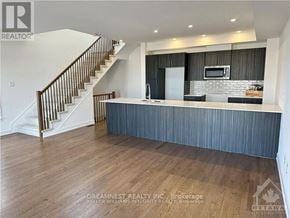 Ottawa townhouse for rent - A modern kitchen with wood flooring and a staircase.