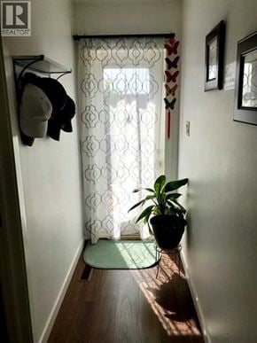 Lethbridge apartment for rent - A hallway with a plant on a mat and a coat hanging on the wall.