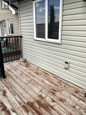 Lethbridge apartment for rent - A deck with a black railing and a window.