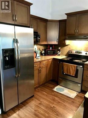 Lethbridge apartment for rent - A kitchen with a stainless steel refrigerator and wooden cabinets.