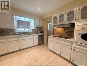 Windsor apartment for rent - A kitchen with white cabinets and a stone backsplash.