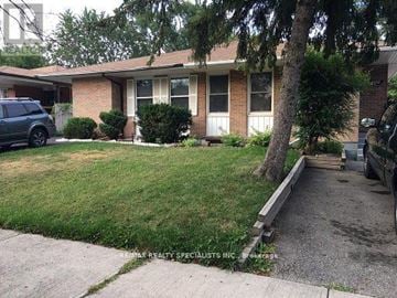 Mississauga (Clarkson) apartment for rent - A house with a green lawn and a tree in front.