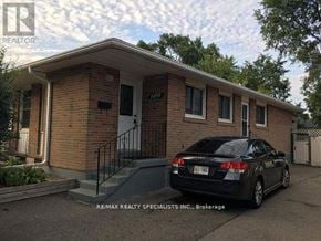 Mississauga (Clarkson) apartment for rent - A black car is parked in front of a brick house.