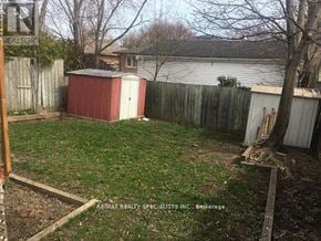 Mississauga (Clarkson) apartment for rent - A backyard with a red shed and a wooden fence.