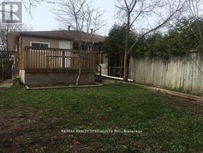 Mississauga (Clarkson) apartment for rent - A backyard with a deck and a fence.