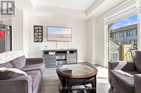 Thorold (Hurricane/Merrittville) townhouse for rent - A living room with a couch, a coffee table, and a television.