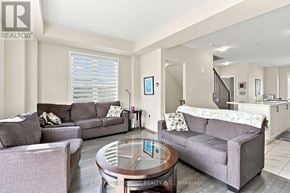 Thorold (Hurricane/Merrittville) townhouse for rent - A living room with a grey couch and a glass table.