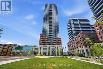 Toronto (Thorncliffe Park) condo for rent - A modern building with a glass facade stands tall in the cityscape.