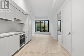 Toronto (Thorncliffe Park) condo for rent - A spacious kitchen with white cabinets and a view of trees through the window.