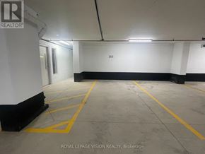 Toronto (Humber Heights) condo for rent - A spacious, empty parking garage with yellow lines on the floor.
