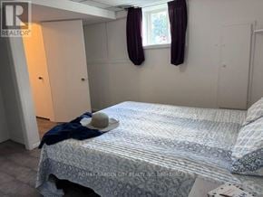 Welland (Lincoln/Crowland) fourplex for rent - A bedroom with a bed, a hat, and a window with curtains.