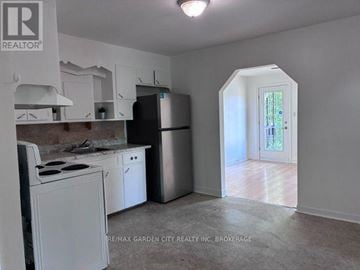 Welland (Lincoln/Crowland) multi-family for rent - A kitchen with white appliances and cabinets is shown.