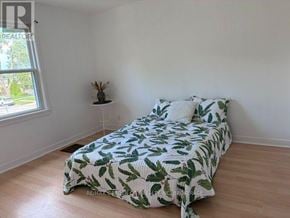 Welland (Lincoln/Crowland) multi-family for rent - A bedroom with a bed covered in a green leaf print bedspread.